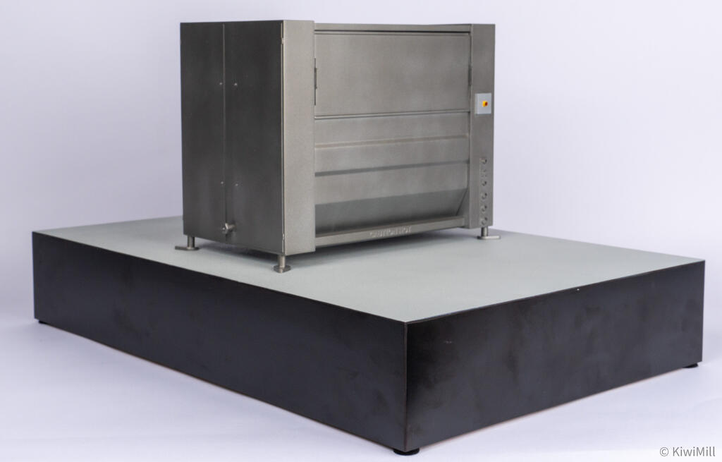 Low rear angle of the chiller scale model showing closed back panels, stop switch box, and end door drain fitting